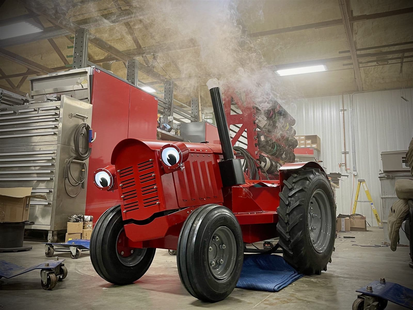 A red Zack with glowing eyes and fog exhaust puffing, coming to life in the Bolt-On Speed shop